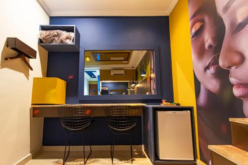 un vestidor con espejo y un bar con taburetes en Soft Motel - USP en São Paulo