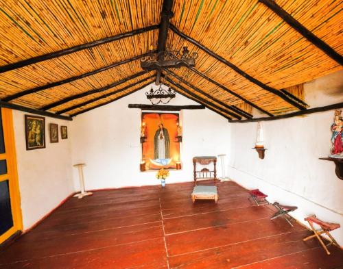 Habitación grande con suelo y techo de madera. en Hotel Museo la Posada del Molino en El Cocuy