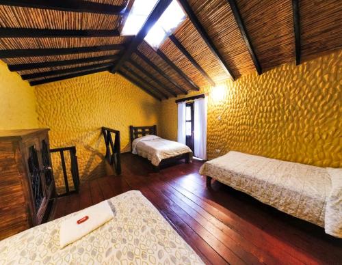 a bedroom with two beds in a room at Hotel Museo la Posada del Molino in El Cocuy