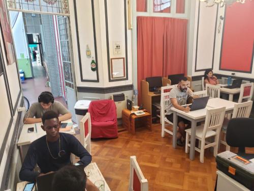 un grupo de personas sentadas en mesas en una habitación en Tinta Roja Residencia Estudiantil en Buenos Aires