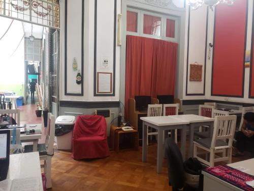 una habitación con mesas y sillas y una cortina roja en Tinta Roja Residencia Estudiantil en Buenos Aires
