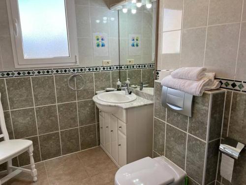 a bathroom with a sink and a toilet and a mirror at Apartamento Casa de Marina in Costa Calma