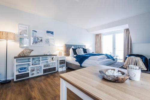 een slaapkamer met een bed en een tafel in een kamer bij Baltic Lagoon Resort direkt am Meer in Fuhlendorf