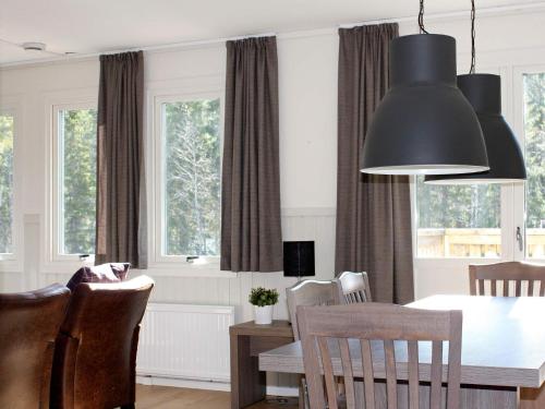 a dining room with a table and chairs and windows at Apartment SÄLEN II in Stöten