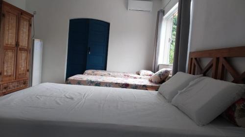 1 dormitorio con 2 camas y ventana en Refúgio Ouro Fino Kitnets Casas e Apartamentos, en Paraty