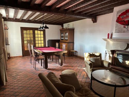 un salon avec une table et une cheminée dans l'établissement La villa Dakoté, à Sassenay