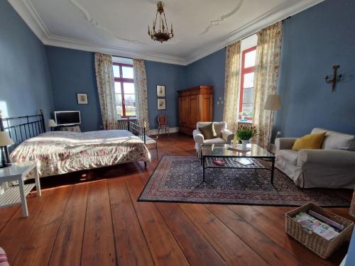 GerdshagenにあるModern Apartment in Satow with Gardenの青い壁のベッドルーム1室、ベッド1台、ソファが備わります。
