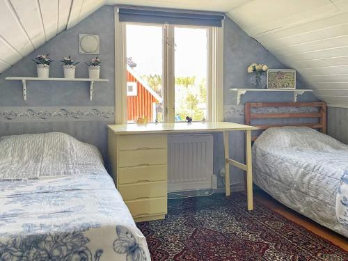 sypialnia z 2 łóżkami, biurkiem i oknem w obiekcie Holiday home HÖGSBY II w mieście Högsby