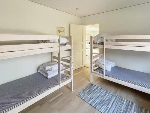 Holiday home YNGSJÖ III في Yngsjö: غرفة بها ثلاثة أسرة بطابقين ومرآة