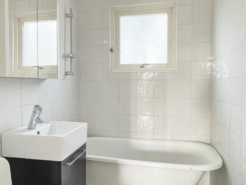Holiday home YNGSJÖ III في Yngsjö: حمام أبيض مع حوض وحوض استحمام