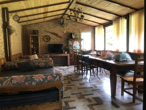 a living room with a table and a dining room at Sítio Solar di Stella in Itatiaia