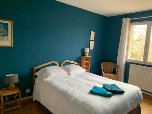 弗朗舍維爾的住宿－La Maison des Palombes，一间卧室配有一张带蓝色墙壁的大床
