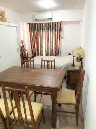 uma sala de jantar com uma mesa e cadeiras e uma cama em Monoambiente - Barrio Martin em Rosário