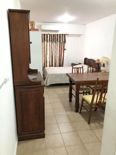 um quarto com uma mesa e uma cama e uma mesa e cadeiras em Monoambiente - Barrio Martin em Rosário
