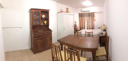 uma sala de jantar com uma mesa de madeira e cadeiras em Monoambiente - Barrio Martin em Rosário