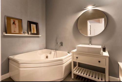 een badkamer met een bad, een wastafel en een spiegel bij Loft incantevole in Vinci