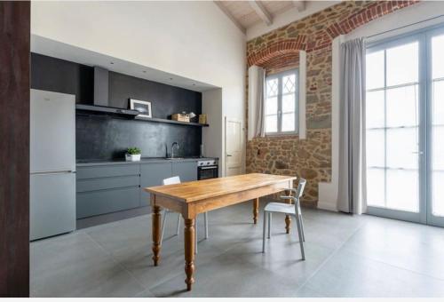 een keuken met een houten tafel en een koelkast bij Loft incantevole in Vinci