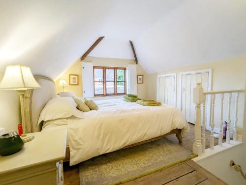 Un dormitorio con una cama grande y una ventana en Truffle Cottage, Chichester en Chichester