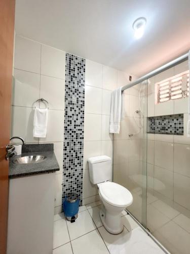 a white bathroom with a toilet and a shower at Apartamentos em Vicente Pires in Brasília