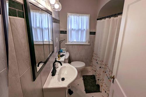 La salle de bains est pourvue d'un lavabo, de toilettes et d'un miroir. dans l'établissement Comfortable & Convenient Home, Sleeps 15, à Sioux Falls