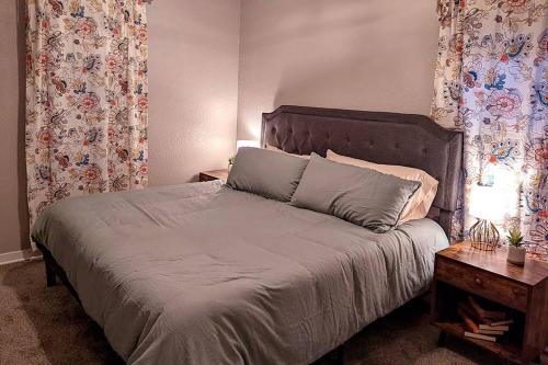 Comfortable & Convenient Home, Sleeps 15 في شلالات سيوكس: غرفة نوم بسرير وطاولة وستائر