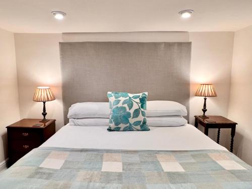 a bedroom with a bed with a pillow and two lamps at Jewel Cottage in Matlock