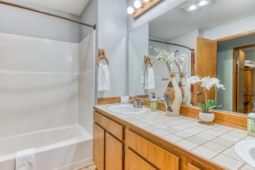 La salle de bains est pourvue d'un lavabo, d'une douche et d'une baignoire. dans l'établissement The Golf Course Cabin, à Welches