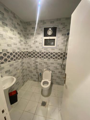 a bathroom with a toilet and a sink at شقة غرفتين وصاله دخول ذاتي in Riyadh