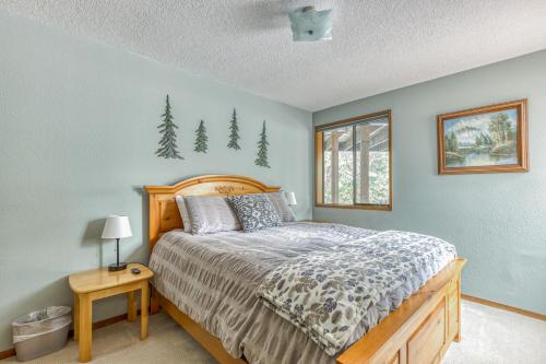 um quarto com uma cama e uma janela com árvores na parede em The Golf Course Cabin em Welches