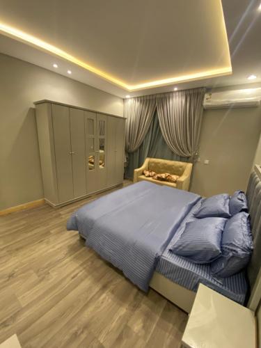 a bedroom with a large bed and a chair at شقة غرفتين وصاله دخول ذاتي in Riyadh