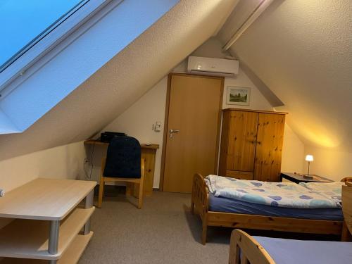 a attic room with a bed and a desk and a table at Fewo Kurth - Haus Dulshorn in Wildeshausen