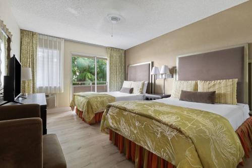 a hotel room with two beds and a window at Plantation Hale Suites in Kapaa