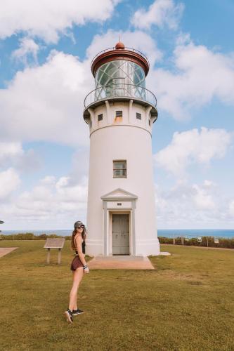 a woman standing in front of a lighthouse at Plantation Hale Suites in Kapaa