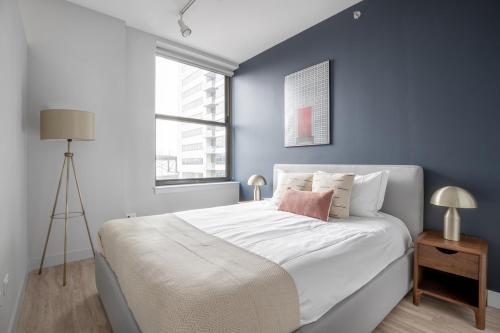 a bedroom with a large bed with a blue wall at Loop 1BR w Deck Gym WD nr W Loop the L CHI-220 in Chicago