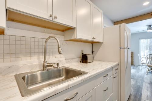 a kitchen with a stainless steel sink and white cabinets at Pet-Friendly Poconos Getaway with Resort Perks! in Lackawaxen