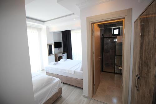 a hotel room with two beds and a bathroom at Piri Reis Butik Hotel in Marmara