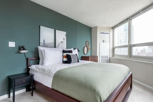 a bedroom with a large bed with blue walls at River N 2BR wGym Deck Pool nr Mag Mile CHI-133 in Chicago