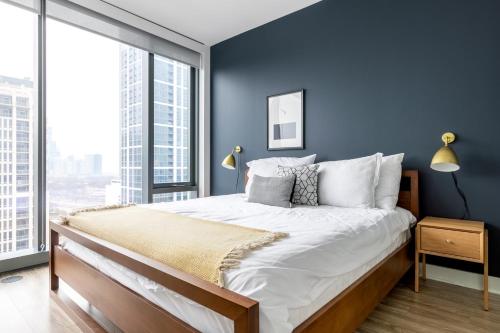 a bedroom with blue walls and a large bed with white pillows at S Loop 1BR w Pool Gym nr Michigan Avenue CHI-84 in Chicago