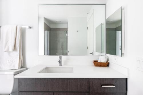 a white bathroom with a sink and a mirror at S Loop 1BR w Pool Gym nr Michigan Avenue CHI-84 in Chicago