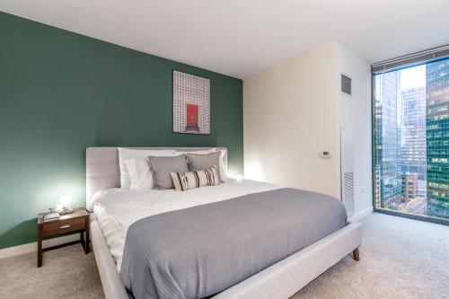 a bedroom with a large bed with a green wall at Loop 1BR w Gym Pool WD nr Financial District CHI-229 in Chicago