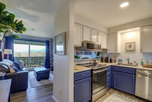a kitchen with blue cabinets and a living room at Walk to the Beach Ocean Shores Condo! in Ocean Shores