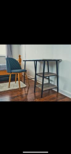 una sedia blu, un tavolo e uno sgabello di Detached House with a private en suite room a Clydebank