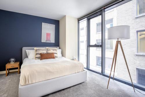 a bedroom with a white bed and a blue wall at Loop 1BR w Gym Pool nr Financial District CHI-233 in Chicago