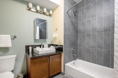 a bathroom with a sink and a tub and a toilet at Loop 1BR w Gym Pool nr Financial District CHI-233 in Chicago