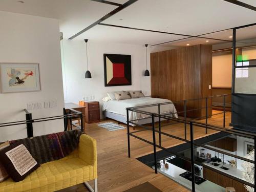 ein Wohnzimmer mit einem Bett, einem Sofa und einem TV in der Unterkunft The orchid terrace in Mexiko-Stadt
