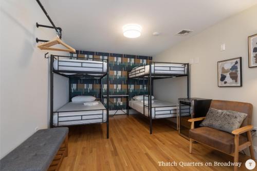 um quarto com três beliches e uma mesa em West Broadway Quarters by Thatch em Boston