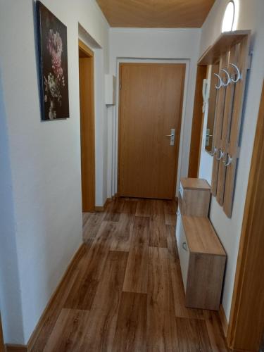 a hallway with wooden floors and a wooden door at Pine Crest Ferienwohnung in Harzgerode