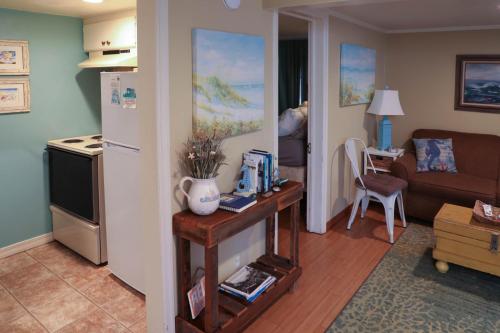 a kitchen and living room with a couch and a refrigerator at Enchanted Cottages by the Sea in Seaview