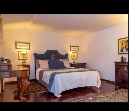 sypialnia z łóżkiem, biurkiem i pianinem w obiekcie Don Camillo Suites w mieście Riposto
