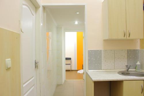 uma pequena cozinha com um lavatório e um corredor em Uneed Rooms Somnium em Kiev